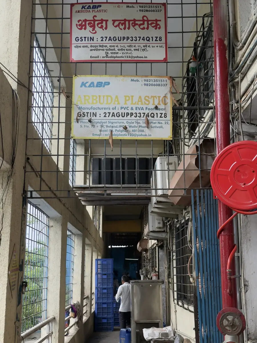 Arbuda Plastic factory entrance with signboards showing the company name, GSTIN and address